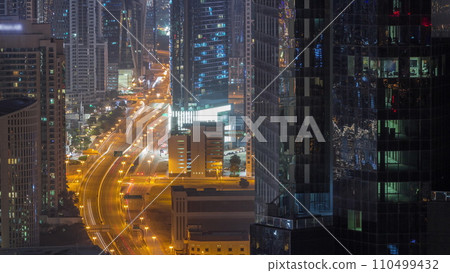 Aerial view from above to a busy road junction in Dubai all night timelapse. Aerial view from above to a busy road junction in Dubai all night timelapse. 110499432