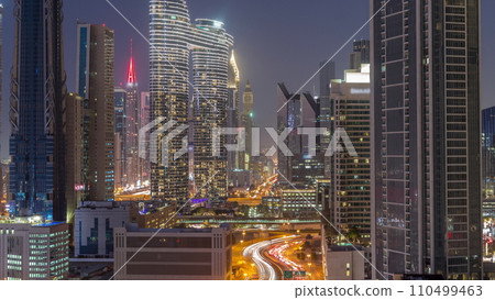 Many towers and skyscrapers with traffic on streets in Dubai Downtown and financial district day to night timelapse. 110499463