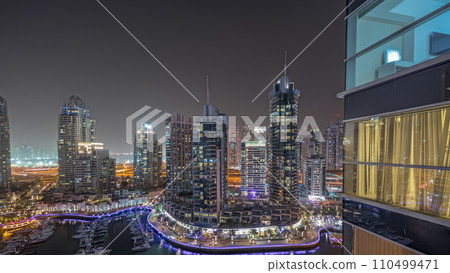 Panorama showing Dubai marina tallest skyscrapers and yachts in harbor aerial night timelapse. 110499471
