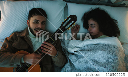 Man sing and Play the guitar in a bed 110500225