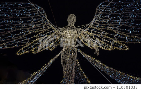 Flying angel Christmas decoration led lights display. Dramatic view of the traditional Christmas decoration lights hanging above Regent Street during dusk. Flying angel Christmas decoration led lights display. Dramatic view of the traditional Christmas decoration lights hanging above Regent Street during dusk. 110501035