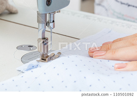 Female hands of a master tailor at work, a sewing machine needle Female hands of a master tailor at work, a sewing machine needle 110501092
