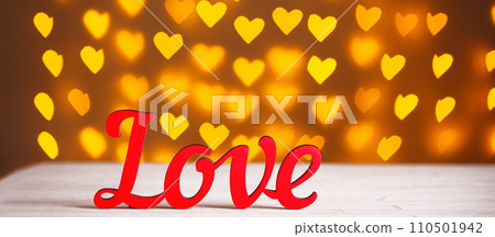 the inscription Love on a wooden background with beautiful hearts made of lights on a blurred background the inscription Love on a wooden background with beautiful hearts made of lights on a blurred background 110501942