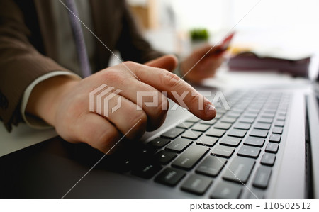 Male arms hold credit card press buttons making transfer Male arms hold credit card press buttons making transfer 110502512