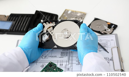 A male repairman wearing blue gloves 110502540