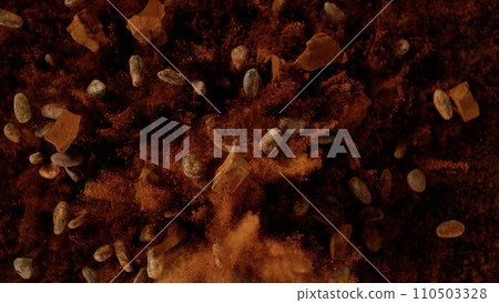 Freeze motion of pieces of chocolate chunks and raw cocoa beans exploding. Top view. 110503328