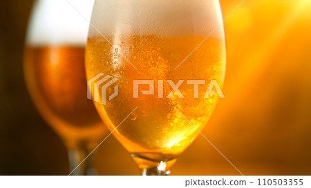 Freshly brewed beer in a pint on orange gradient background, close-up 110503355