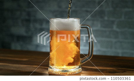 Freshly brewed beer in a pint on grey brickwall background, close-up 110503361