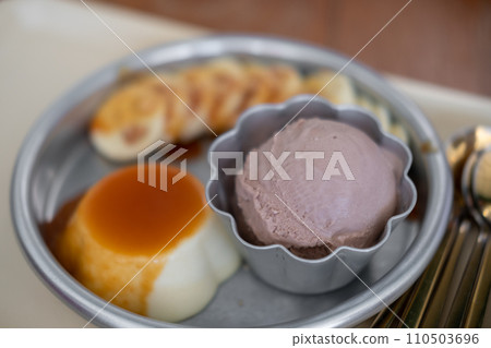 Chocolate ice cream served with pudding and sliced banana Chocolate ice cream served with pudding and sliced banana 110503696