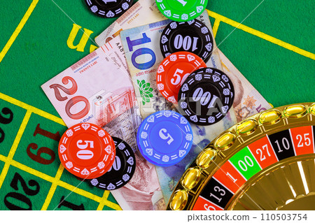 On green gaming table there are roulette, Georgian banknotes in lari poker chips. 110503754