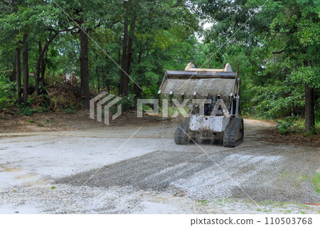 Bobcat mini loader is moving bucket of crushed stone gravel during construction operations Bobcat mini loader is moving bucket of crushed stone gravel during construction operations 110503768