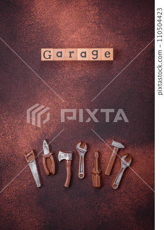 Tools and inscriptions symbolizing repairs or a garage and its attributes on a plain background 110504423