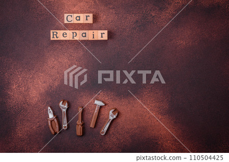 Tools and inscriptions symbolizing repairs or a garage and its attributes on a plain background Tools and inscriptions symbolizing repairs or a garage and its attributes on a plain background 110504425