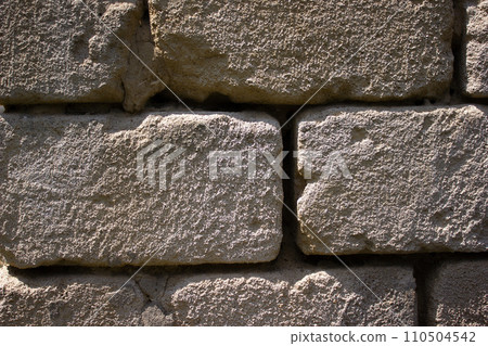 Old uneven crumbling brick, wall - background Old uneven crumbling brick, wall - background 110504542