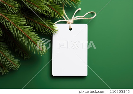 White blank price tag on green background with Christmas tree branch. Copy space. White blank price tag on green background with Christmas tree branch. Copy space. 110505345