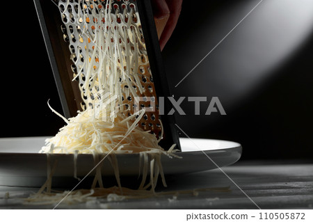 Grated cheese and grater. 110505872
