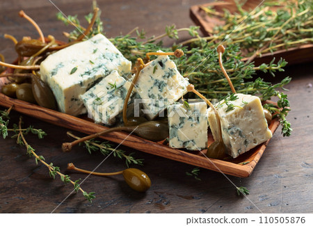 Blue cheese , capers and branches of thyme . 110505876