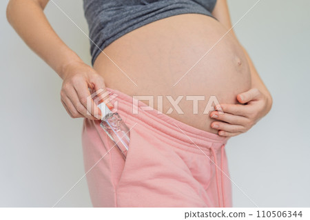Expectant mom ensures safety, applying gel sanitizer for a clean and healthy pregnancy 110506344