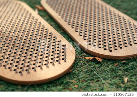 Banner sadhu board made of natural wood on the grass close-up. Practice nailing and meditation Banner sadhu board made of natural wood on the grass close-up. Practice nailing and meditation 110507126