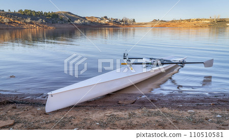 Coastal rowing shell on a shore of Horsetooth Reservoir in fall or winter scenery with a low water level. Coastal rowing shell on a shore of Horsetooth Reservoir in fall or winter scenery with a low water level. 110510581