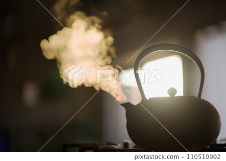 Boiling water in an iron kettle in the morning glow Boiling water in an iron kettle in the morning glow 110510902