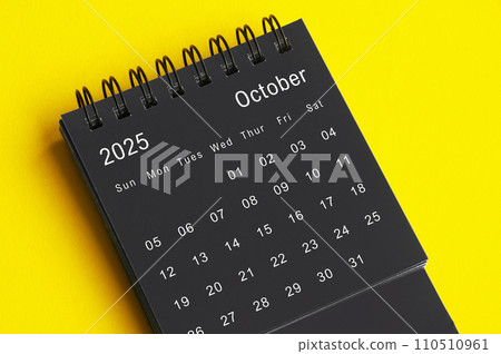 October 2025 black and white desk calendar on yellow cover background. Calendar concept October 2025 black and white desk calendar on yellow cover background. Calendar concept 110510961