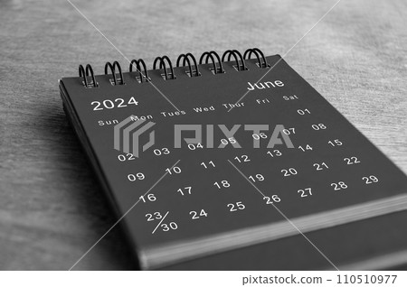 Black and white June 2024 desk calendar on wooden desk. New month concept Black and white June 2024 desk calendar on wooden desk. New month concept 110510977