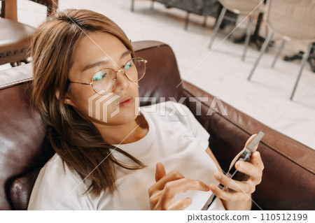 Bored woman using smartphone boringly in the cafe. 110512199