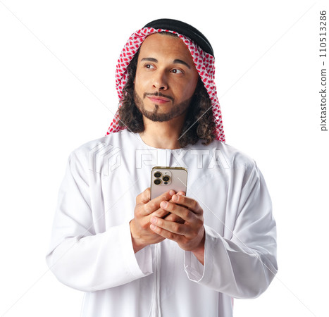 Young Arab man in traditional dress thobe using smartphone at white background Young Arab man in traditional dress thobe using smartphone at white background 110513286