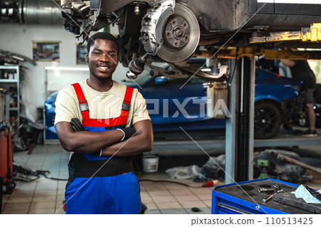 Portrait of young african man car service worker wearing uniform standing in garage 110513425