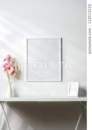 White wooden frame on white wall above the table White wooden frame on white wall above the table 110513538