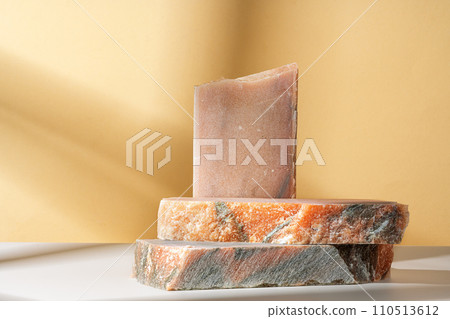 Pieces of granite stones against beige background with shadows Pieces of granite stones against beige background with shadows 110513612