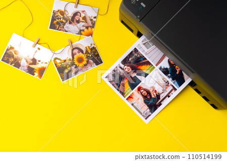 Printer printing colorful photos of people close up, yellow background 110514199