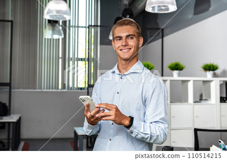 Young handsome entrepreneur using his mobile phone in the office Young handsome entrepreneur using his mobile phone in the office 110514215