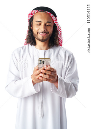 Young Arab man in traditional dress thobe using smartphone at white background 110514325