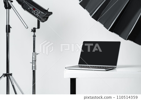 Laptop with black screen and photography equipment in photostudio Laptop with black screen and photography equipment in photostudio 110514359