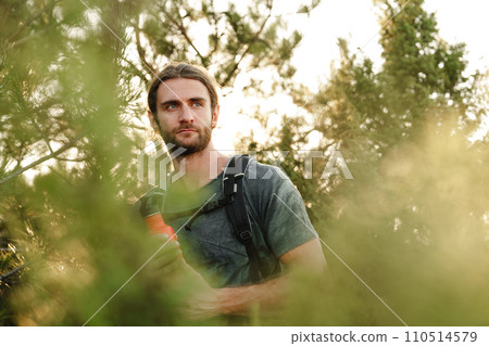 Hiker man with backpack holding thermos in his hand 110514579