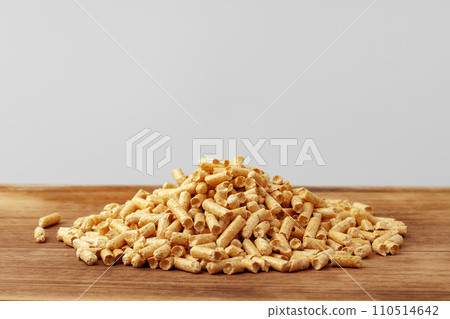 Heap of wooden pellets biofuel on wooden table Heap of wooden pellets biofuel on wooden table 110514642