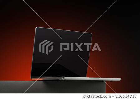 Laptop with black screen against dark red background Laptop with black screen against dark red background 110514715