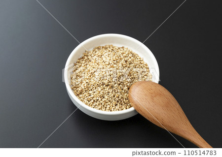 烤芝麻和木湯匙在碗裡，黑色背景 110514783