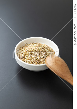 烤芝麻和木湯匙在碗裡,黑色背景 烤芝麻和木湯匙在碗裡,黑色背景 110514787
