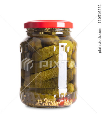 Cornichons, pickled gherkins in a glass jar. Crunchy pickles. Small cucumbers, pasteurized and preserved in brine of vinegar, salt, mustard seeds and chilis. Close-up, front view on white background. 110516231