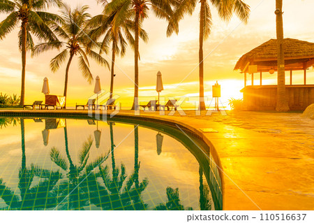 Umbrella and chair around swimming pool in hotel resort with sunrise in morning Umbrella and chair around swimming pool in hotel resort with sunrise in morning 110516637