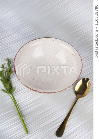 White empty deep clay plate with a spoon on a white background. 110519790
