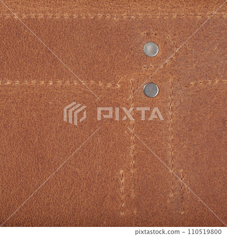 Texture of natural brown leather with stitching and metal buttons. 110519800