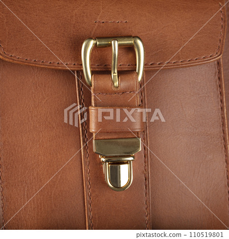 Part of a brown genuine leather bag with a metal latch. 110519801