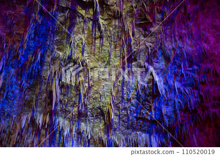 Karst cave, amazing view of stalactites and stalagnites in colorful bright light, beautiful natural landmark in touristic place. 110520019