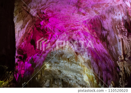 Karst cave, amazing view of stalactites and stalagnites in colorful bright light, beautiful natural landmark in touristic place. 110520020