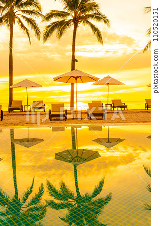 Umbrella and chair around swimming pool in hotel resort with sunrise in morning Umbrella and chair around swimming pool in hotel resort with sunrise in morning 110520151