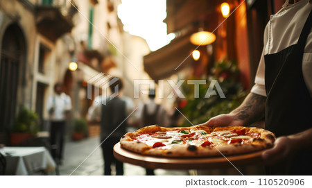 Idea for a restaurant menu, waiter serving pizza on a wooden tray in a cafe on a street in old Rome, selective focus on pizza, lunch concept with copy space 110520906